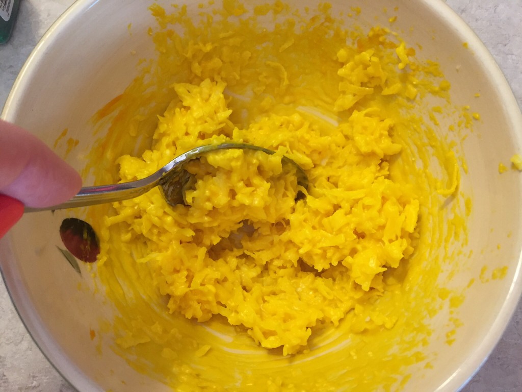 Adding food coloring to make yellow cookies.