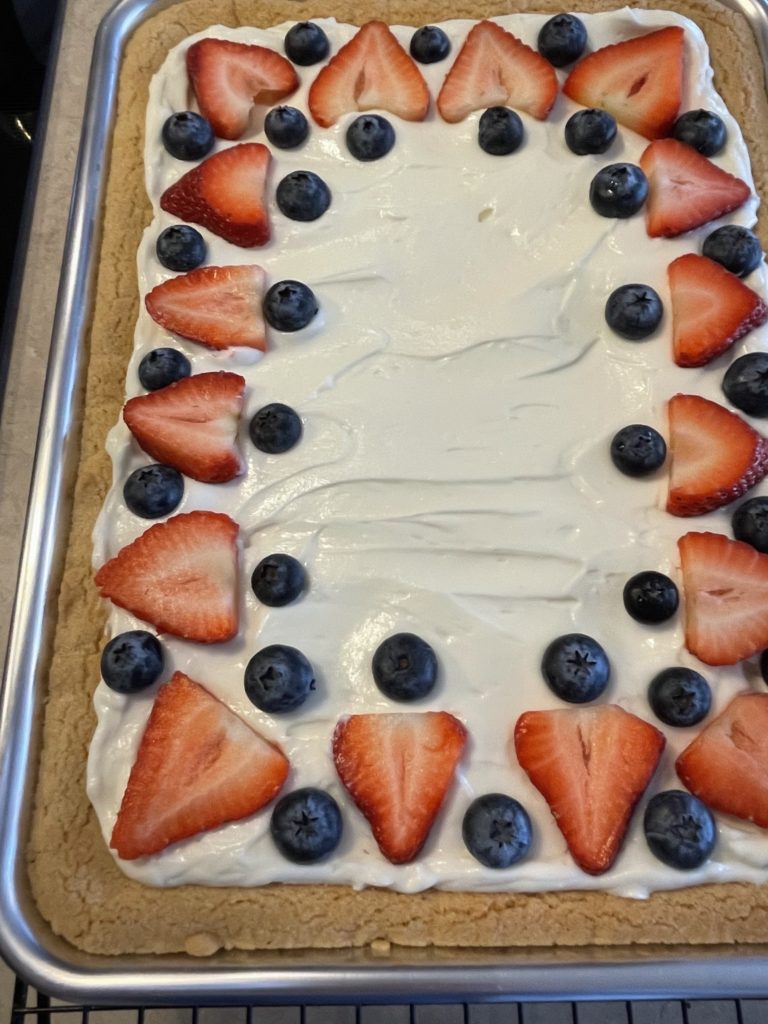 Adding fruit to the fruit pizza