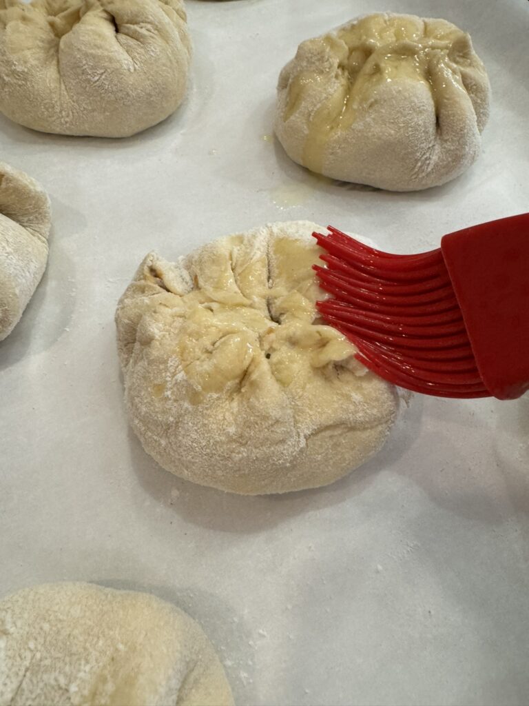 Brush cheeseburger pockets with butter.